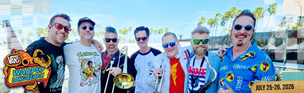 Reel Big Fish after their epic return to the stage during Warped Tour Long Beach. Ed Beach, Scott Klopfenstein, Dan Regan, Derek Gibbs, John Christianson, Matt Appleton and Aaron Barrett stand with their arms around each other backstage.